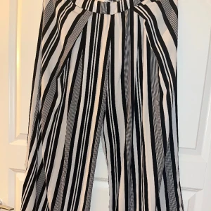 Visa, svart-vita randiga, lätta byxor i nyskick! - Använda 2 ggr, nyskick. Väldigt lätta, sköna och mjuka. Pressveck.