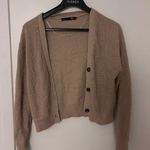 Kofta  - En fin brun/beige stickad kofta från lager 157. Den är lite använd men skicket är ändå väldigt bra. 