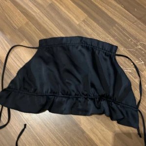 En topp med öppning i ryggen  - En topp med öppning i ryggen! Använd två gånger så i fint skick! Storleken är 42 men passar även till dom som har en mindre storlek för att de är snörning i ryggen! 