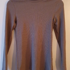 Tight polotröja  - Oanvänd polotröja i medium. Långa ärmar. Skitsnygg fast inte på mig. Färgen är ljust brun.