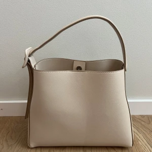 Väska Mango - En helt oanvänd beige handväska från Mango. Både kort och långt band. 