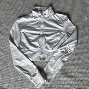 Vit croppad tröja från Shein - En vit croppad tröja från Shein med dragkedja framtill. Tröjan har långa ärmar och en hög krage. Bra skick. Köpt secondhand. Skriv för fler bilder eller frågor! 🤍