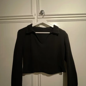 Långärmad crop top - Crop top med långa ärmar och krage. Köpt på Plick och saknar märke-och storlekstag men passar bra på storlek M. Använd men i fint skick. 