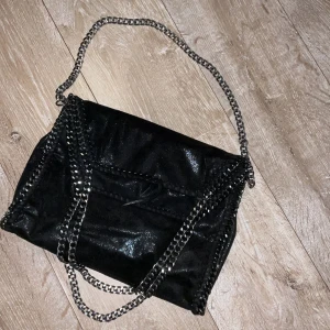 Stella McCartney liknande väska!! - Sjukt snygg Stella McCartney liknande väska i färgen svart, inga defekter utom att snöret lossnat väldigt lite, inget stort dock. Skulle säga att väskan är i storlek M och perfekt för skolstarten. Kan sänka pris vid snabb affär❣️❣️
