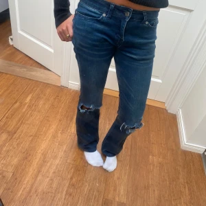 Bootcut jeans  - Mörkblåa Bootcut jeans med två hål i vardera knä. Jättefina men börjar bli försmå. Jättebra skick. Skriv för funderingar och prisförslag🥰🥰