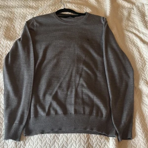 Grå J.lindberg tröja - Säljer nu en riktigt fin tröja ifrån J.lindberg i merinoull. Säljer den för att den aldrig kommer till användning. Den är i toppskick och är inte använd mer än 5 gånger. Ställ gärna frågor om ni undrar något😃