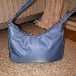 Jag säljer en blå liten handväska från Gina tricot 