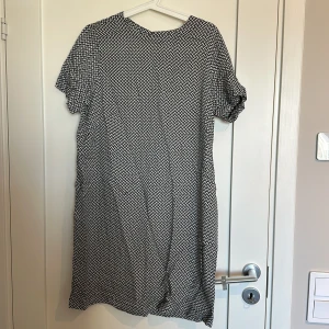 Klänning  - En klänning i fint skick som man stänger med två knappar på ryggen så den blir lite öppen i ryggen.  Djur finns i hemmet!