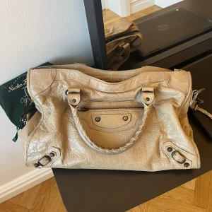 Balenciaga city bag - Säljer nu min balenciaga city bag. Köpt på en second hand affär i Canada. Tyvärr är äkthetsbeviset borttappat, men kommer med dustbag. Perfekt rymlig väska till ex skola. Några mindre defekter men inget som påverkar.