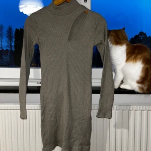 Zaraklänning militärgrön - Militärgrön Zaraklänning i ett ribbstickat tyg. Fin grön färg, liten polokrage och långa ärmar. Klänningen går precis nedanför rumpan på mig som är 177 cm!