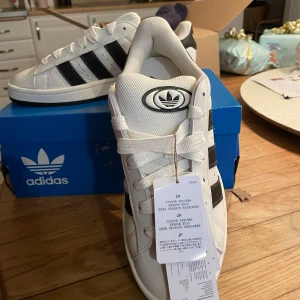 Svart/vita Campus 00s  - Jättesnygga campus i beige/vitt och svart❤️ Oanvända och kommer tillsammans med lådan💕 Säljer då de tyvärr inte passar mig❤️ Öppen för prisförslag och köp nu💕