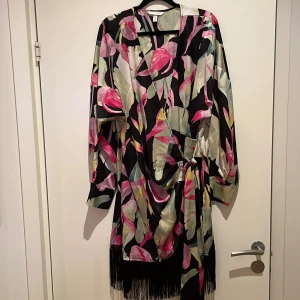 Omlottklänning med fransar nedtill från H&M - Normal i storleken och omlottknytning samt fransar nedtill.