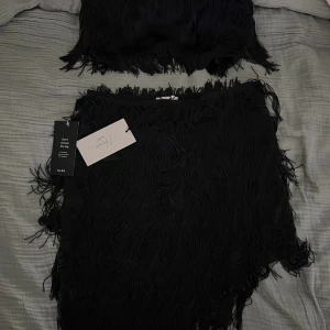 Set - Fint set med fransar från NA-KDxHanna Schönberg. Kjolen är oanvänd och toppen är använd 1 gång. Dragkedja i sida på både topp och kjol.