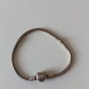 Pandora armband - Ganska rostigt men går att fixa. Äkta från Pandora. Använt några gånger, säljer för det är för stort på mig. Armbandet är 19cm 