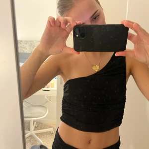 Festtopp - Snygg svart snedskuren topp som passar perfekt till fest. Från NA-KD och i storlek S.