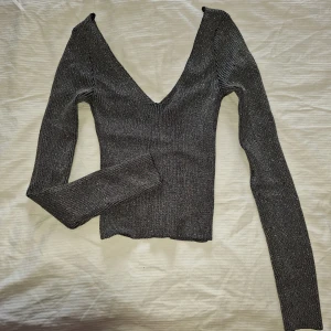 Topp - Snygg Glittrig topp som är lite som en croptop. Sitter jätteskönt och är lite stretchig! Stl xs men skulle säga att den sitter som en S också.  
