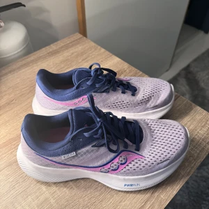 Löparskor Dam - Ett par löparskor från Saucony Ride 16. Dom är i en fin ljus lila färg och är i storlek 38,5. Inte använd mycket, max 5 gånger. Nypris ligger på ungefär 1700kr