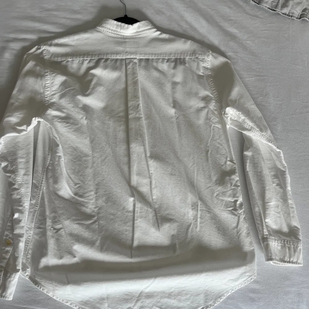 En Ralph Lauren skjorta i vit med mörkblå logga storlek L. En mindre brun fläck som jag inte vårdat med vanish men kan ha möjlighet att försvinna. Typisk sommarskjorta som är köpt under sommaren 2023z. Skjortor.