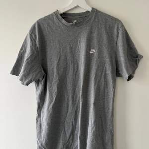 Unisex T-shirt från Nike. Grå och i använt skick. Storlek L. Nike-loggan är broderad. T-shirt i bomull. 