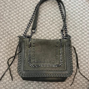 Axelrems väska  - Axelremsväska från Zara i mörkgrön mocka. Lite stilen i ena remmen, skickar bild vid behov. Okej skick utöver det