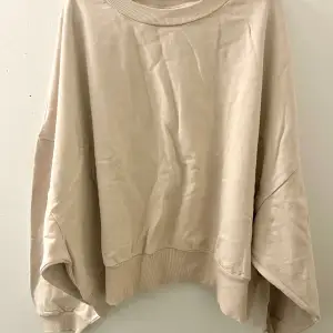 Sweatshirt i beige med stora vida ärmar.  Strl. 52 normal i storleken, inte överdrivet oversized.  Använd fåtal gånger, skicket är som ny.