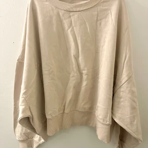 OVERSIZED SWEATSHIRT  - Sweatshirt i beige med stora vida ärmar.  Strl. 52 normal i storleken, inte överdrivet oversized.  Använd fåtal gånger, skicket är som ny.
