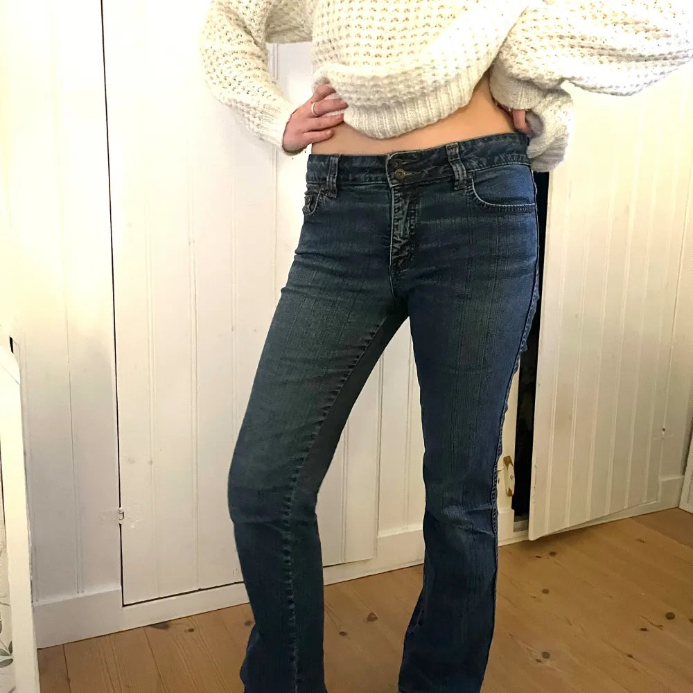 Blå lågmidjade jeans som inte kommer till användning men sitter perfekt till kroppen för dem i storleken xs/s Midjemått: 40cm Innerbenlängd: 73cm Två snygga knappar i fram😍. Jeans & Byxor.