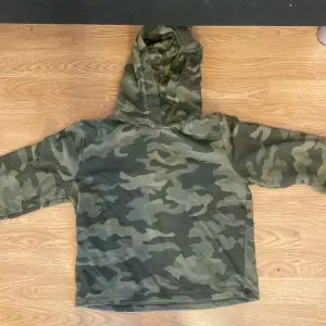 En lite kortare hoodie med kamouflage mönster. Lite tunnare, och knappt använd.