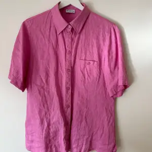 Så snygg rosa linneskjorta. Köpt vintage och sparsamt använt. Storlek 38 (jag har vanligtvis 34/36, sitter snyggt oversize). 100% linne. Så snygg till våren!!  Djur- och rökfritt hem.