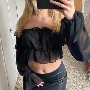 Snygg fest topp - Superfin fest topp i svart, lite genomskinligt material med detaljer i ärmarna, aldrig använd 