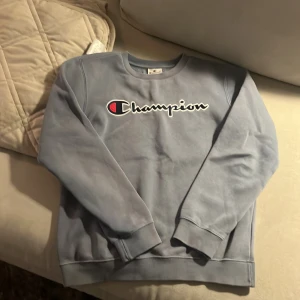 Blå tjock tröja från champion  - Storlek 150 / 155 junior mycket bra skick  