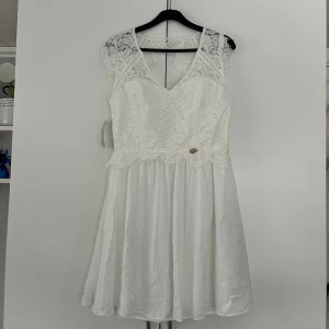 Studentklänning - Vit studentklänning från Bubbleroom. Spets och öppen i ryggen. Aldrig använd och har lapparna kvar