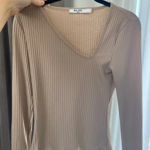Ribbad tröja - Beige ribbad tröja från NA-KD med sne halsrigning 