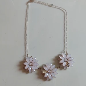 Halsband med blommor - Superfint halsband! Dock så saknas två av bladen på blommorna, därav det billiga priset.❤️ Tycker inte att det är något man tänker på dock.