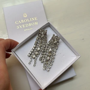 Strass Örhängen  - Storlek: 70 x 20 mm Vikt: 22 g Förgyllning: 18K Guld / Rodium Världens högsta kvalitet på kristaller Graverad logotyp  