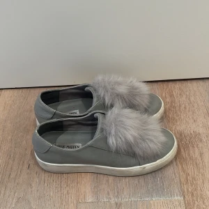 Steve madden sneakers - Ett par jättesöta gråa steve madden skor med två fluffbollar på. Skicket är väldigt bra då jag inte annvänt de särskilt mycket, men sulan är lite smutsig men det går lätt att tvätta!Står ingen storlek i men passar 38-39❤️‍🔥