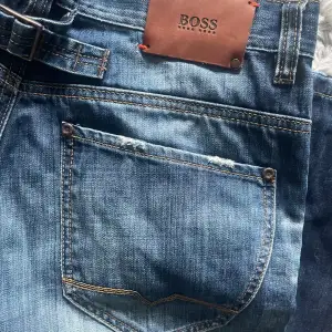 Säljer ett par jeans från hugo boss i fint skick! Lite rippade men det är designen