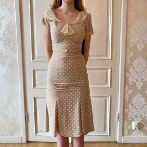 Prickig klänning, Stop Staring! - Jättefin beige prickig klänning i skönt material. Storlek M. Lite stretch. Modellen på bilden är 173 cm och har storlek 38 i de flesta andra kläder. Aldrig använd. Vi har lagt ner vår klänningsbutik och säljer ut. Ny pris är 2000-3000kr