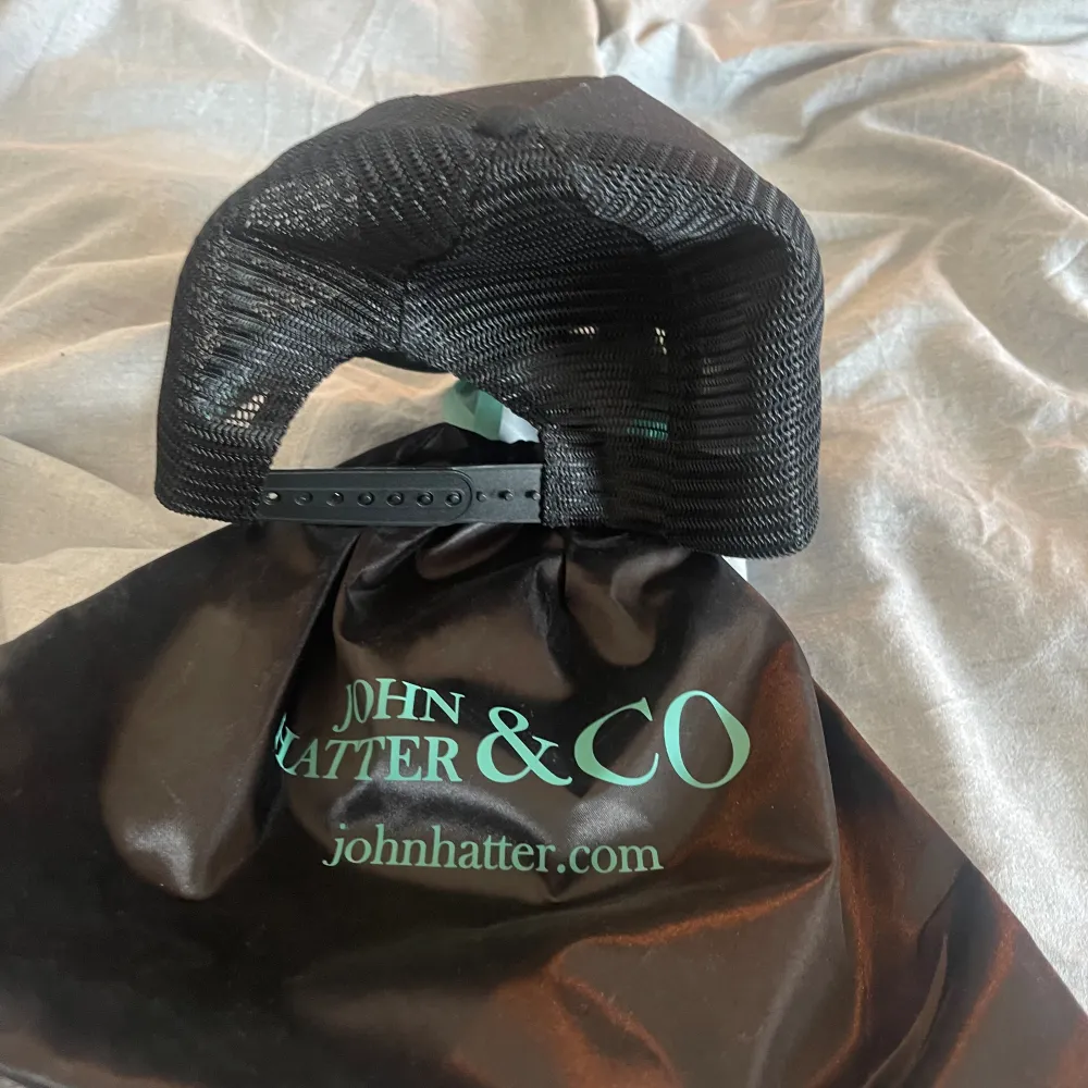 En svart John Hatter Rubber Cap ”Dressed for Success (plattan med text är i plast). Kepsen är inte använd och kepspåsen följer med i köpet. Nypris 500 men säljer för 250🤝. Accessoarer.