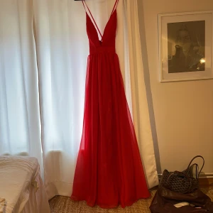 RÖD BALKLÄNNING - Superfin baklänning men djup v-rigning och öppen i ryggen. Klänningen är helt oanvänd och jag säljer för att jag hittade en annan.  