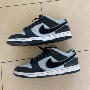 Nike Dunks Chenille Swoosh (grå, svart) - Säljer dessa då det inte riktigt är min stil. Skorna är knappt använda, 9/10 skick.  Ny pris: 3000kr 