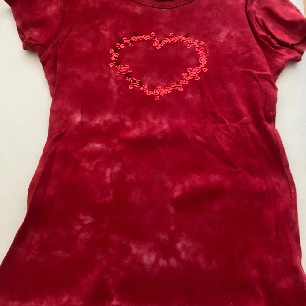 En röd vintage tröja med ett hjärta av paljetter! Hör av dig om fler frågor❤️. T-shirts.