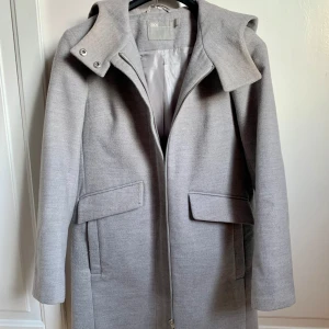 Ljusgrå kappa - Asos - Ljusgrå kappa från Asos i storlek 32. Dubbla fickor framtill. Endast använd ett fåtal gånger 😂