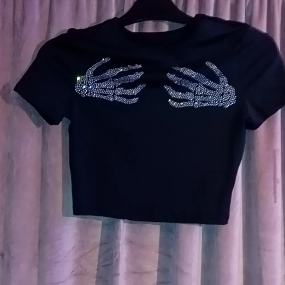 En svart t-shirt med döskalle händer . T-shirts.
