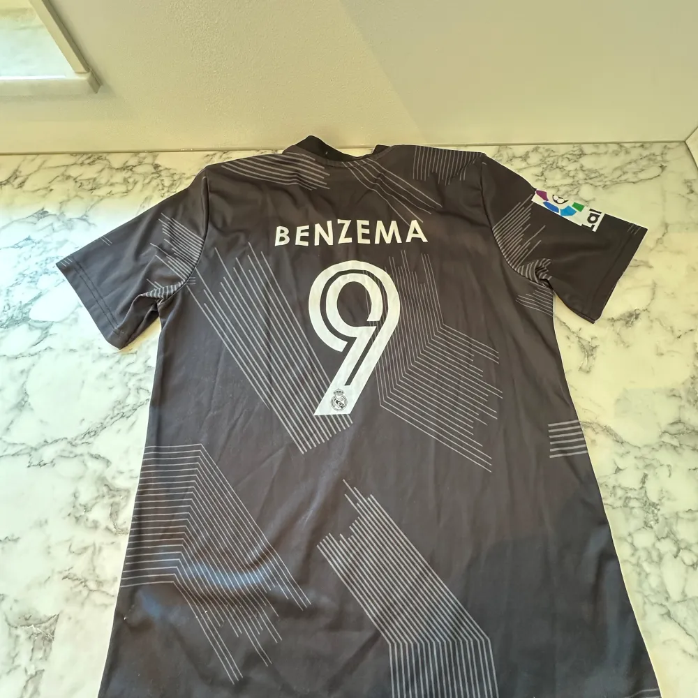 Real Madrids speciella t-shirt från säsongen 22/23. Tröjan är i storlek 176/XS och passar bra på kroppen. Tröjan har Benzema nummer 9 där bak. . Sport & träning.