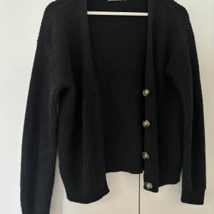 Svart stickad kofta - Svart kofta från pieces med bruna knappar. Den är stickad i ett ribbat mönster. Koftan är använd men i gott skick💕