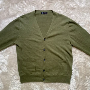 Olivgrön Stickad Cardigan - Säljer nu denna gröna cardigan i fint material. Skick 10/10, inga defekter. Storlek M men passar S utan tvekan. Skriv för fler frågor eller funderingar. 🤩