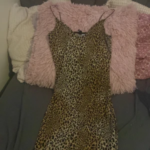 Leopard klänning  - Det är en ganska festlig klänning men santidigt bekväm så man kan sova i den kan användas på olika sätt klänningen är lite över knäna kort den är i bra skick inte riktigt min stil den va en present har havt på mig den 2-3 ggr 