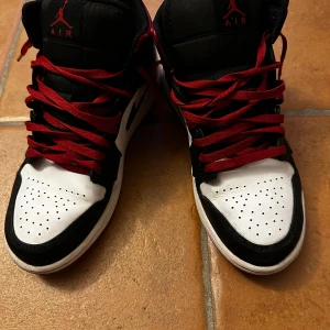 Röda / Svarta Jordan 1s Mid - Dom här skorna har använts i 3 månader, bra skick, köpte dom för 1700kr.