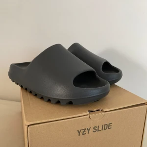 Yeezy Slide Onyx - Yeezy slides onyx  Använda 1-2 gånger  Som nya - passar strl 44  Pris kan diskuteras  **kvitto finns**